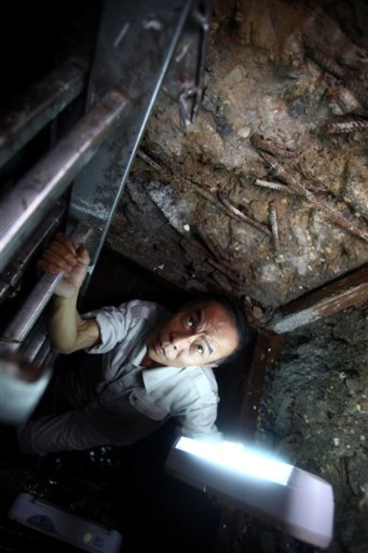 In this photo taken Sept. 27, 2011, a technician of the Metropole Hotel climbs from a Vietnam war underground bunker which was discovered beneath a bar in the hotel's garden in Hanoi, Vietnam. A Vietnamese doctor said that the bunker sheltered American folk singer Joan Baez, American actress Jane Fonda and other foreign war correspondents during the Christmas Bombings in 1972. 